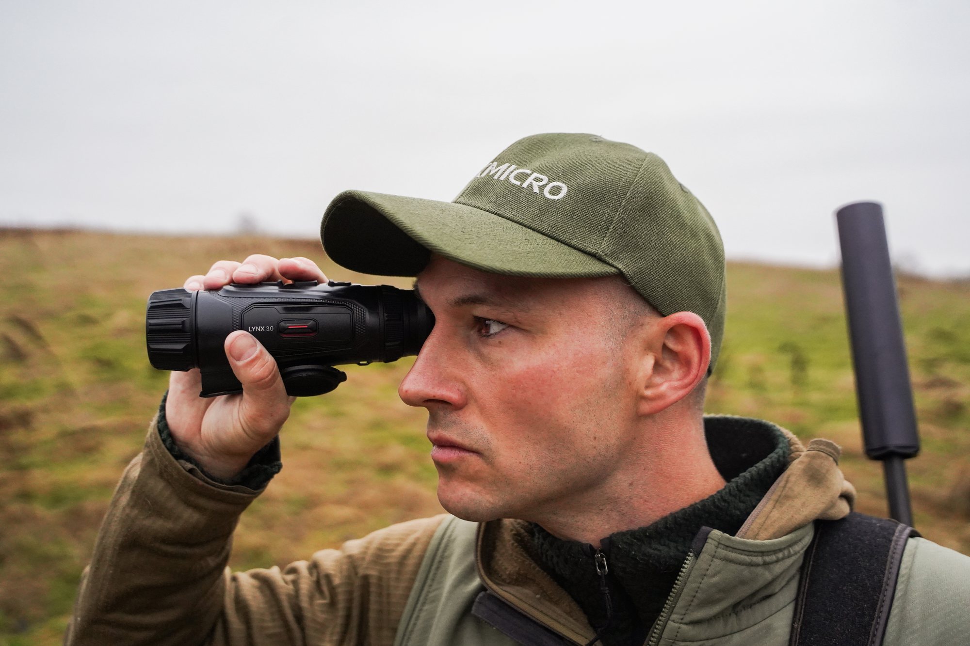 Jägare spanar med HIKMICRO LYNX 3.0 termisk monokulär mot ögat över ett höstfält